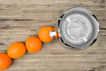 Top view of oranges prepared to be squeezed on an electric citrus juicer