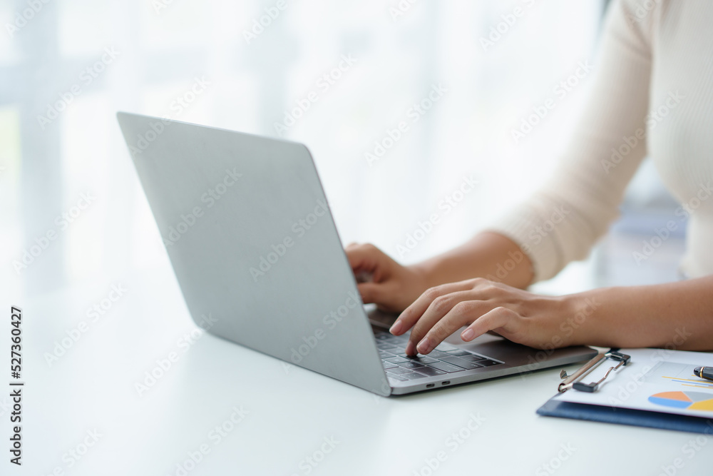 Poster close-up of a woman's hands sitting intently typing using laptop computer at the office fluently and