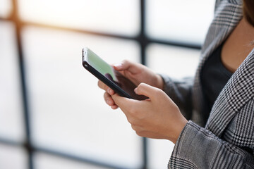 Close-up of a woman using a smartphone to work on various application including mobile transaction to send messages, LINE, and various business information sent via social media.