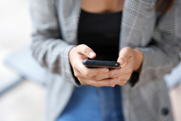 Close-up of a woman using a smartphone to work on various application including mobile transaction to send messages, LINE, and various business information sent via social media.