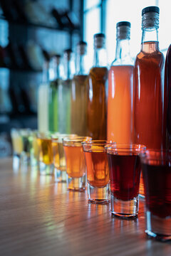 collection set of colored alcohol tincture or liquor with shot glass and bottles