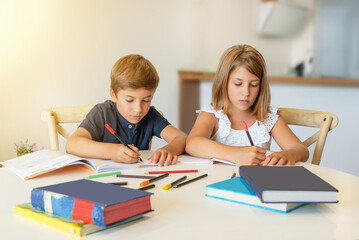 Children concentrating on drawing and studying at home. Kids doing homework in the classroom. Back to school