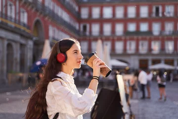 Crédence de cuisine en verre imprimé Madrid Young female tourist listening to music and walking through the streets of Madrid.