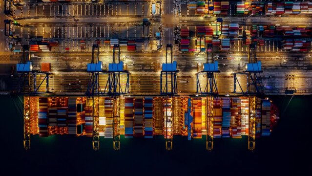 Time lapse of Container ship loading and unloading at night in port.