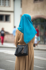 Portrait on back view of Veiled Muslim woman standing in the street - 527366876