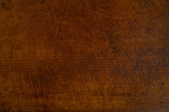 Close-up of worn antique cutting board with knife cut marks