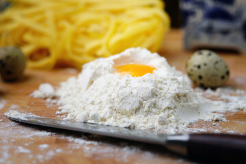 Fototapeta na wymiar On the table is flour with an egg for Italian pasta. Homemade food. Rustic.