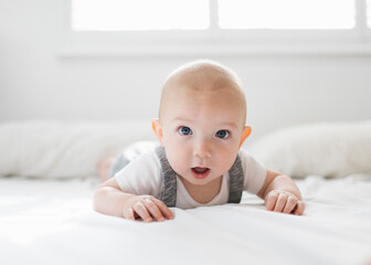 Portrait of baby boy (6-11 months) lying on bed