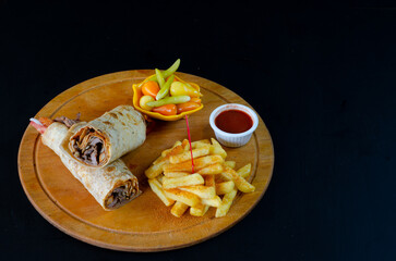 Doner kebab on wooden board on black background. Doner kebab in lavash bread.
