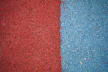Fototapeta premium Rubber crumb for covering sports grounds and playgrounds in red and blue colors