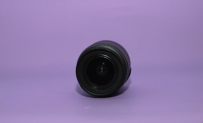Black dslr lens on purple background