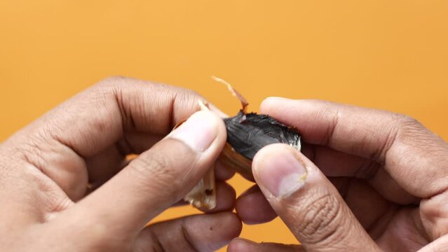 taking skin off from a black garlic