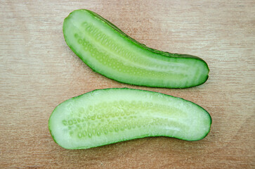 cucumber cut in half on a wooden background, close-up