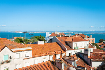 Fototapeta premium View of the city and Orange Clay Rooftops overlooking the Tagus River in Lisbon, Portugal