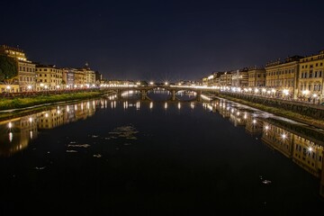 Night view of Florence with the Arno river in the foreground