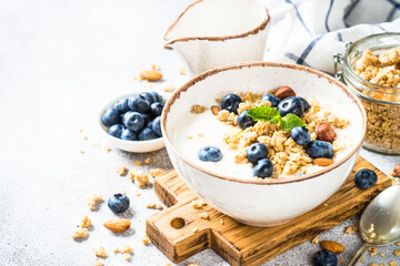 Yogurt with granola and fresh berries at stone table. Healthy food, snack or breakfast.