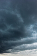 Obraz premium The dark sky with heavy clouds converging and a violent storm before the rain.Bad weather sky.