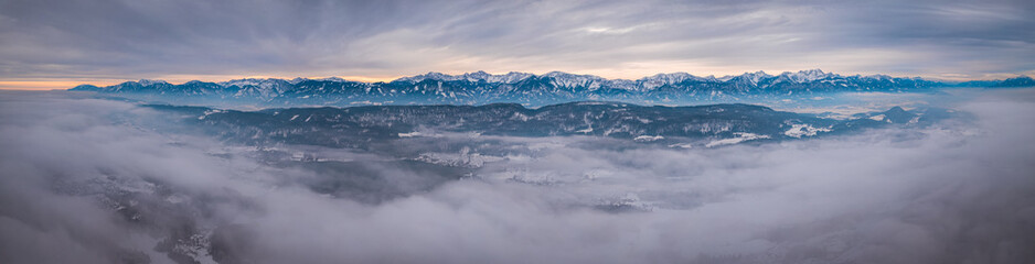 Naklejka na ściany i meble Karawanen in Kärnten im Winter mit Wolken und Nebel
