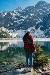 A woman is standing on the shore of a lake. Morskie Oko, Tatras mountains.