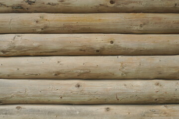 Naklejka premium a wall made of a round wooden beam