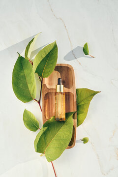 Natural Serum Golden With Colloidal Gold With Leaves On A Wooden Tray, Podium