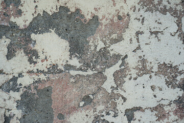 Fragment of a wall with scratches and cracks. Abstract background of an old shabby painted white wall close up.