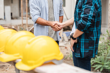 A supervisor giving a handshake on the construction site as a sign of collaboration, partnership, and the notion of people