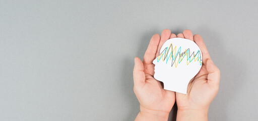 Holding a head in the hands, epilepsy disorder awareness, brain waves,mental health care, paper cut out
