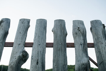 Upward angle of cheap old wooden slab fence texture on a metal frame