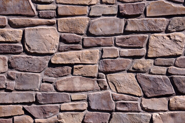 Close-up partial view of a reddish colored wall of concrete stones