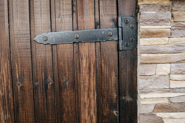 Planked varnished wooden door texture. With heavy bar hinges