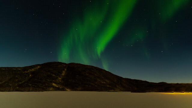 Polarlichter &uuml;ber einer Bergkuppe und einem Schneefeld, Norwegen