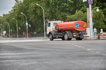 MINSK, BELARUS - JULY 20, 2022: A special machine waters the streets in strong wind and rain