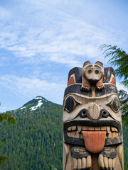 Mountains standing tall behind carved totem pole