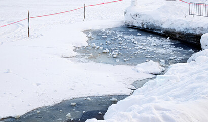 Melting of ice on the reservoir. Thin Ice warning sign. A sign warns of danger as ice thaws