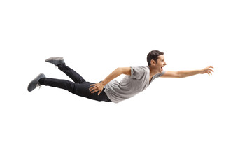 Casual young man flying and reaching for something