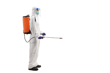 Man in a hazmat suit carrying a disinfectant bottle on his back