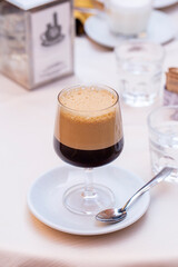 Caffè shakerato in a tall glass, in italian cafe. Cold shaked coffee with a foam made in a shaker...