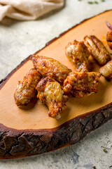 skewers of chicken wings with red onion on the board on stone table, macro close up, vertical