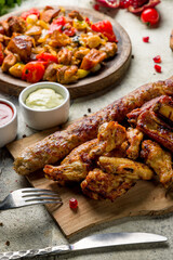 platter of different kebabs, pork,beef,chicken,lamb,veal,salmon, lula kebab on stone table macro close up, vertical