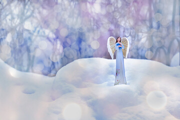 a guardian angel in a blue robe with a book in the snow on a background of multicolored brilliant...