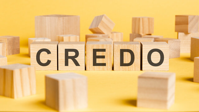 the word credo written on wooden cubes on yellow background