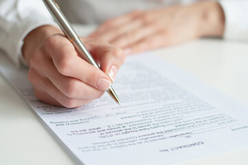 close up of a woman signing contract