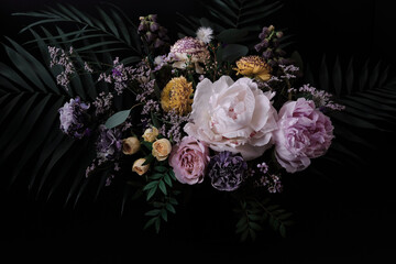 Beautiful bouquet of peonies and different flowers on a black background. Floral background....