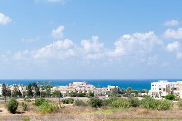 Cyprus landscape. View of the city. Limestone buildings by the sea. Sea and mountains.