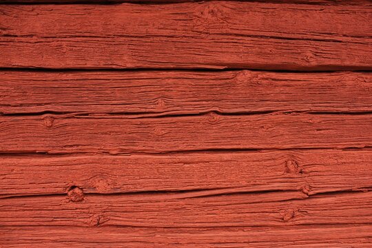 Close up of a wooden cottage with deep Falu red or falun red paint. 