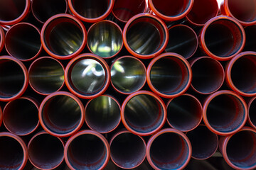 Large pile of orange plastic PVC pipes.