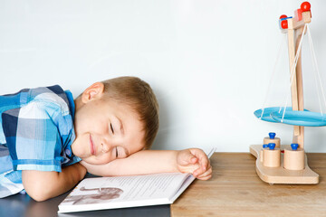 Zmęczone dziecko zasypia - marzenie - książka dla dzieci - świat wyobraźni i marzenia - obrazy, fototapety, plakaty