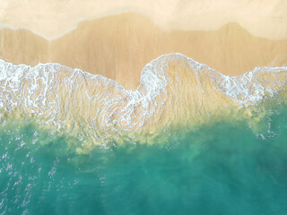 An aerial view of a tropical sandy beach and blue ocean.