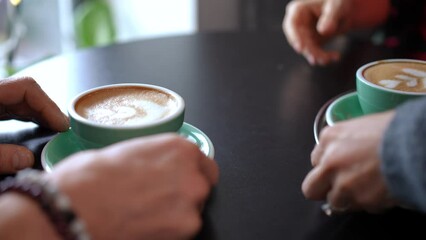 Tracking shot of waitress bringing coffee cups to table in cafe leaving. Unrecognizable professional Caucasian woman serving hot drink for couple of clients indoors. Employment and service concept